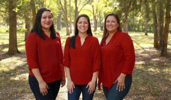 Dallas oral surgery team members in red shirts outdoors